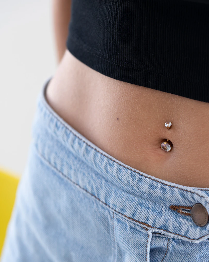Bauchnabelpiercing mit großen Steinen in der oberen und unteren Kugel