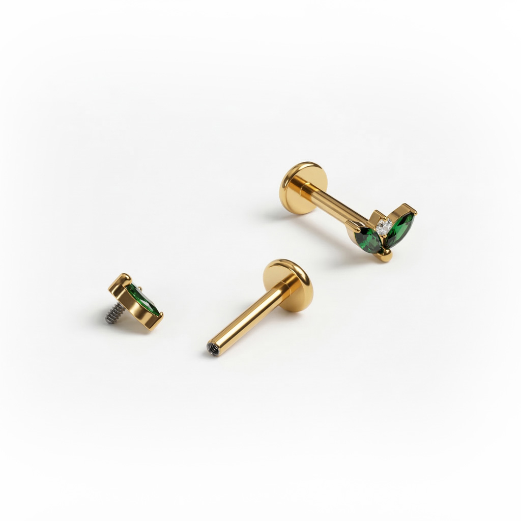 Titan-Labret mit zwei smaragdgrünen Schmucksteinen